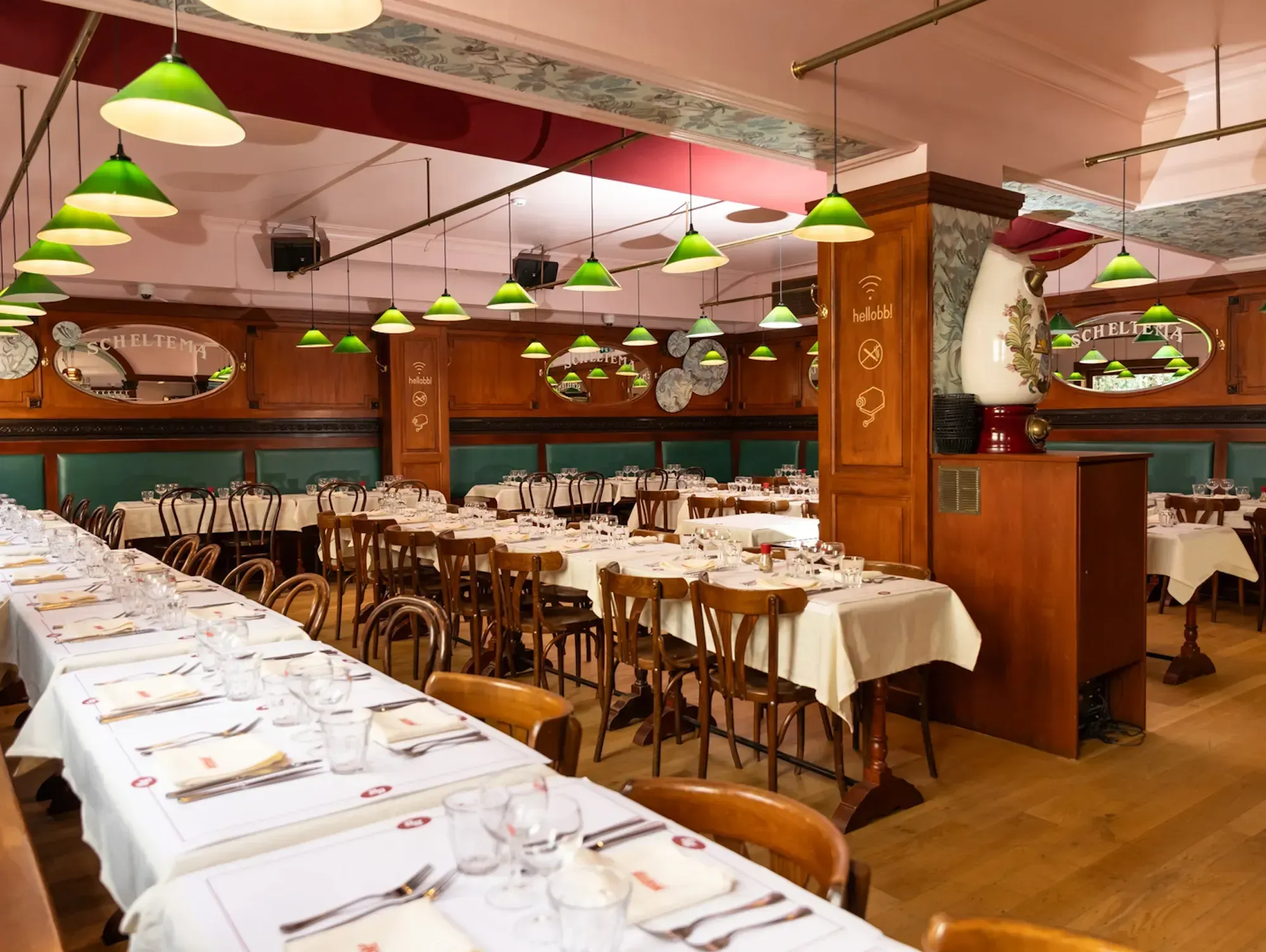 The dining room at Bouillon Bruxelles, white tablecloths and green lamps